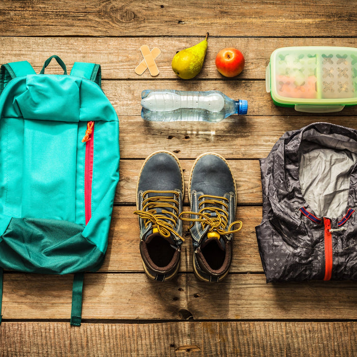 Summer hiking gear on a wooden backdrop