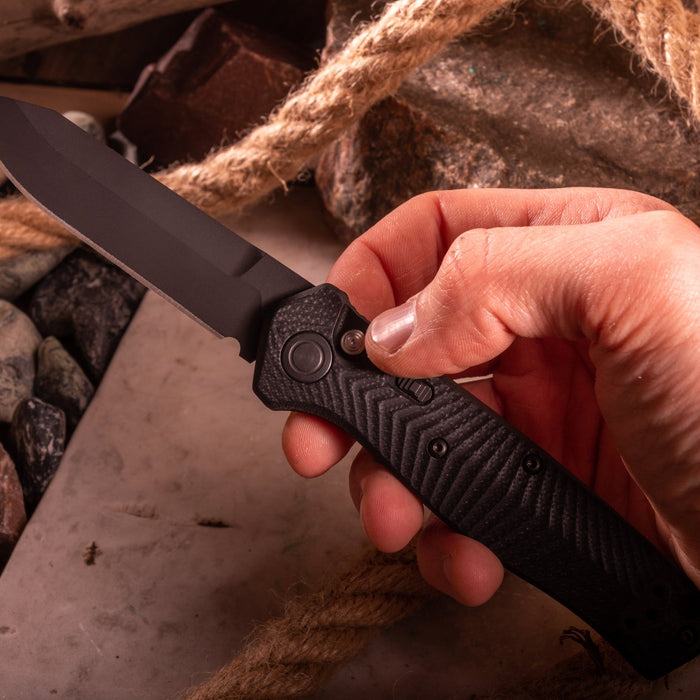 A man’s hand holding a Benchmade EDC knife
