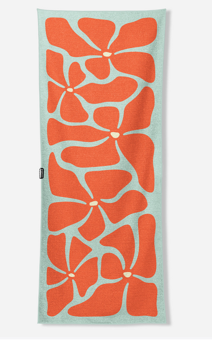 A rectangular knit scarf featuring a retro floral pattern in vibrant orange on a light mint green background, shown flat against a neutral off-white backdrop.