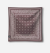 A square bandana scarf in a dusty mauve-brown color, featuring a white paisley border and a central grid of small white crescent moon and star motifs. A small black brand tag is visible on the bottom-left corner, set against a clean light gray background.