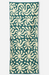 A rectangular fabric item, likely a towel or blanket, featuring a repeating cream-colored abstract floral or starburst pattern on a dark teal-green background.